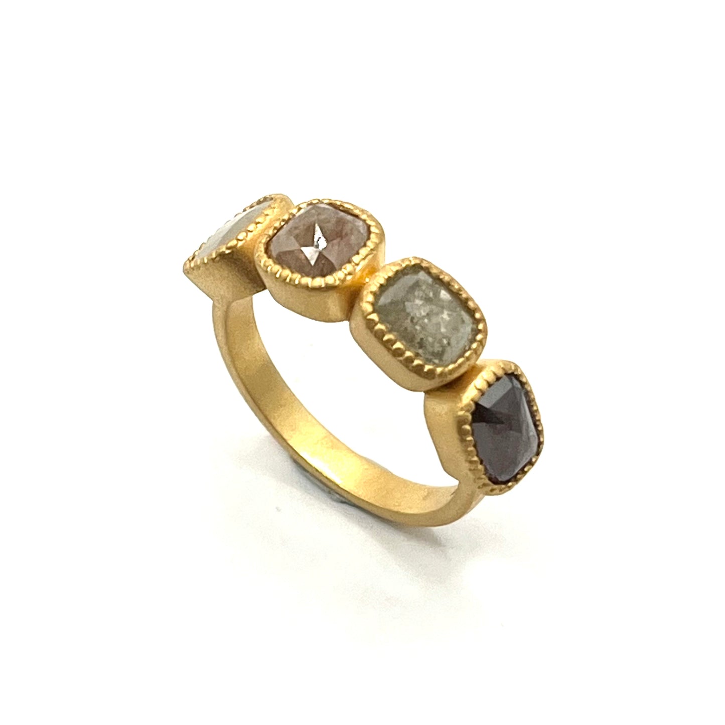 Gold ring with four gemstones on a white background