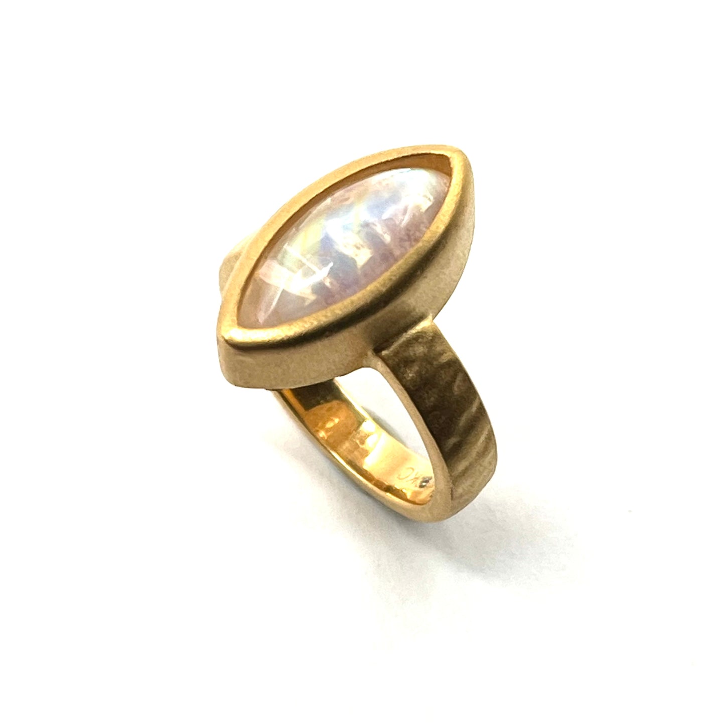 Gold ring with a moonstone on a white background
