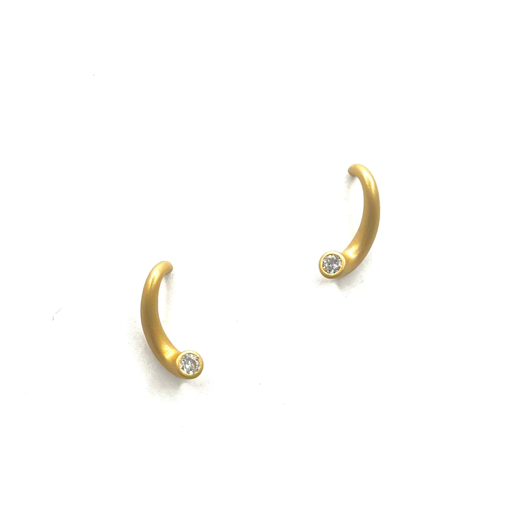 Gold hoop earrings with small diamonds on a white background