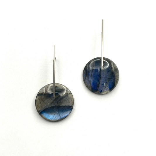 Pair of round earrings with blue and black design on a white background